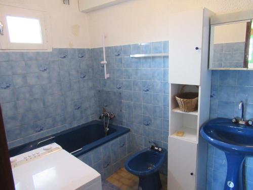 ein blaues Badezimmer mit einer blauen Badewanne und einem Waschbecken in der Unterkunft Lou camparol in Villeneuve