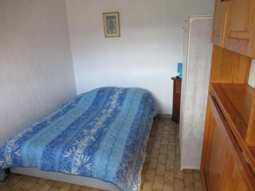 ein Schlafzimmer mit einem Bett mit einer blauen Decke in der Unterkunft Lou camparol in Villeneuve