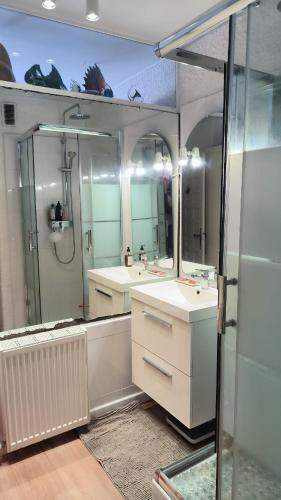 une salle de bain avec deux lavabos et une douche dans l'établissement Appart modernise vue mer ambiance Marine, à Saint Cyprien Plage