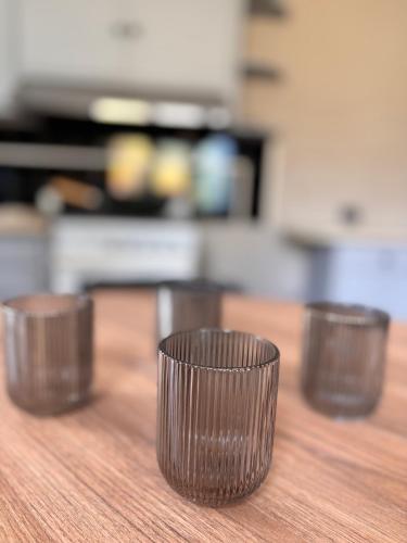 three plastic cups sitting on top of a wooden table at Apartamento Penacchi in Tandil