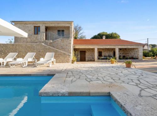 a villa with a swimming pool and a house at Holiday Home Stari Dvori in Šibenik