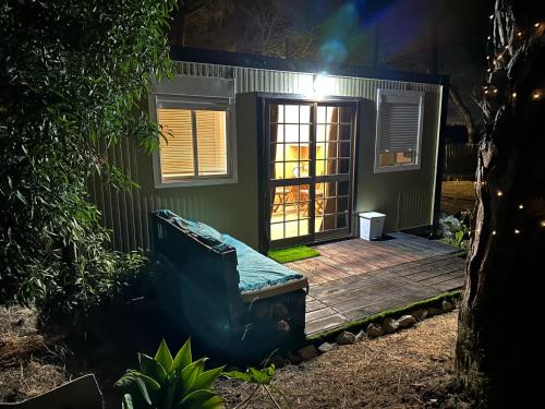 a small house with a wooden deck with a door at Eco-friendly beach house in Sesimbra