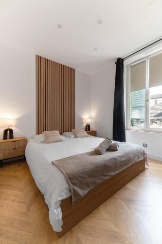 un grand lit dans une chambre avec une grande fenêtre dans l'établissement Chez Virginie Triangle d'Or, à Vichy