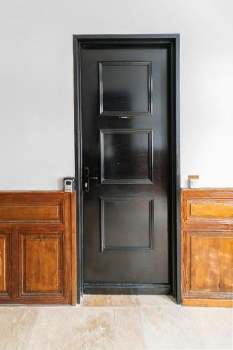 a black door in a room with wooden cabinets at Chez Juliette Triangle d'Or - Rez de Chaussée in Vichy