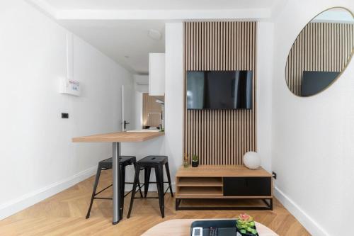 a small kitchen with a table and stool in a room at Chez Juliette Triangle d'Or - Rez de Chaussée in Vichy