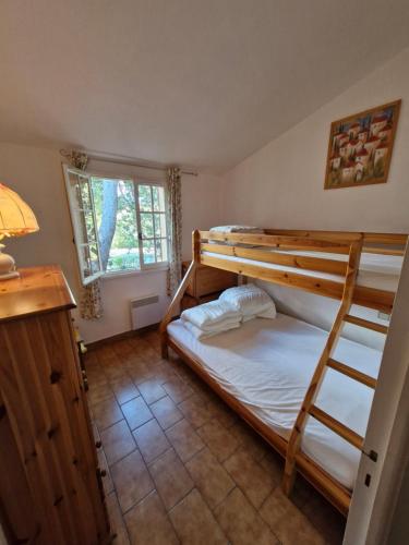 une chambre avec deux lits superposés et une fenêtre dans l'établissement Cavalaire sur mer maison de vacances, à Cavalaire-sur-Mer