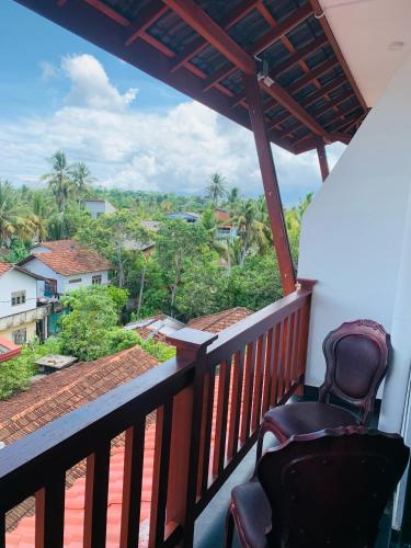 a balcony with a view of the jungle at Lucky Monkey Inn and Restaurant in Weligama