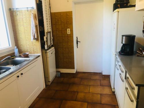 a small kitchen with a sink and a door at Villa Le Pin in Rognes
