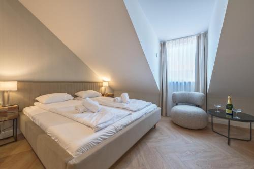 a bedroom with a large bed and a chair at Retro Boutique by NorthSide Apartments in Gdańsk