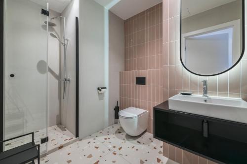 a bathroom with a toilet and a sink and a mirror at Retro Boutique by NorthSide Apartments in Gdańsk