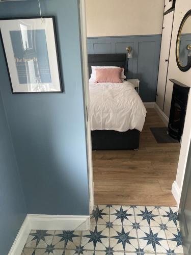 a bedroom with a bed and a tile floor at Seaside Cottage in Spanish Point in Spanish Point