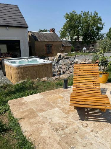 a wooden bench sitting next to a hot tub at BERRY's CHARM in Le Pêchereau