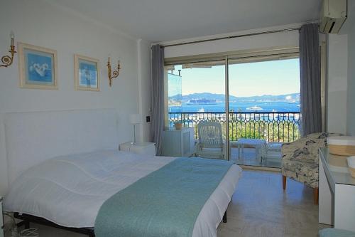 une chambre avec un lit et une vue sur l'océan dans l'établissement Vue unique sur toute la baie de Cannes et la mer, à Cannes