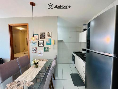 a kitchen with a stainless steel refrigerator and a table at Tambaú Flex Home - LikeHome in Tambaú