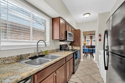 a kitchen with a sink and a refrigerator at LSU Tiger Den in Baton Rouge