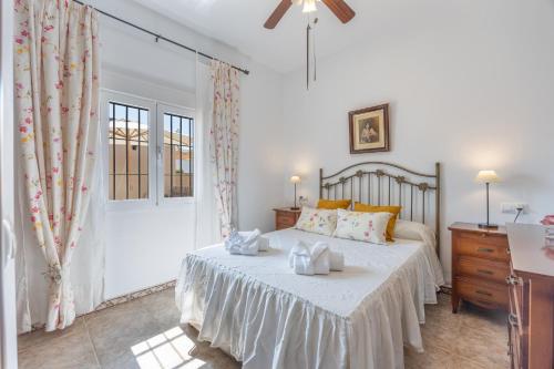 ein Schlafzimmer mit einem Bett, einer Kommode und einer Tür in der Unterkunft La Solana in Chiclana de la Frontera