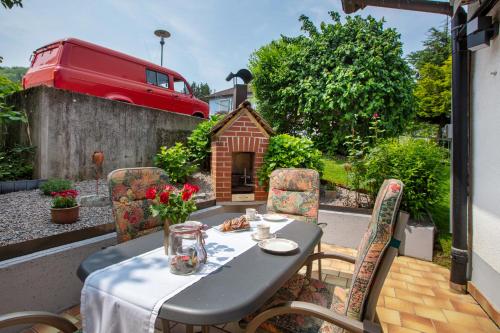 a table and chairs on a patio with a dog house at Haus Petra in Kandern