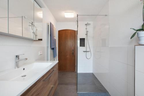 a white bathroom with a sink and a shower at Haus Petra in Kandern