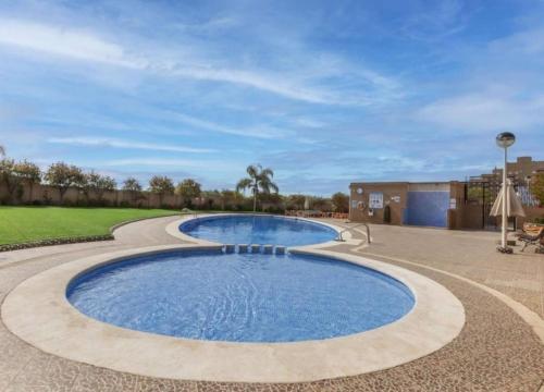 a large pool with blue water in a patio at Oropesa twin horizons in El Borseral