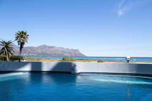 a swimming pool with a view of the beach at Ocean Breeze Hotel in Strand