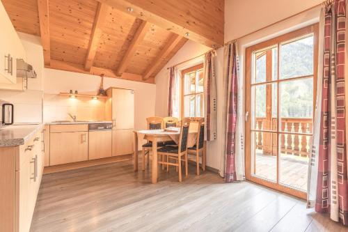 a kitchen with a table and a large window at Steineggerhof in Valle Di Casies