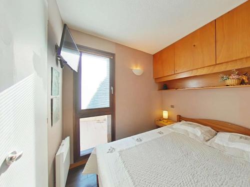 une chambre avec un lit blanc et une fenêtre dans l'établissement Magnifique Appt 2 pièces avec Terrasse Sud proche commerces - Le Grand-Bornand - FR-1-241-105, au Grand-Bornand