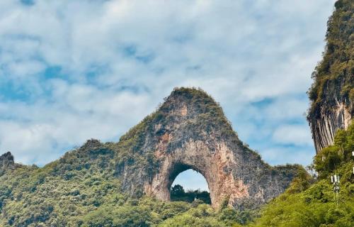 a mountain with an arch in the middle at Li-river Island Resort Xingping Yangshuo in Yangshuo