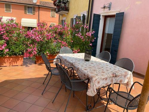 a table and chairs on a patio with pink flowers at La Casa Di Mimi in Bardolino