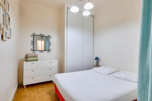 une chambre avec un lit blanc et un miroir dans l'établissement GuestReady - Cosy stay with Terrace in Carré d'Or, à Nice