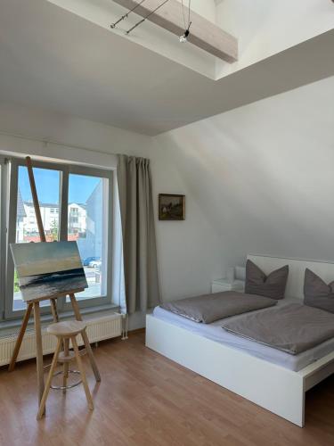 a bedroom with a bed and a painting on a easel at Birnbom Warnemünde in Warnemünde
