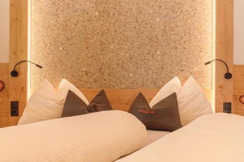 a bedroom with a bed with pillows and a wall at Steineggerhof in Valle Di Casies