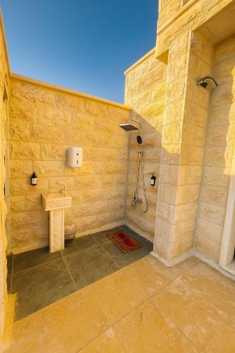 a stone bathroom with a shower and a toilet at Jordan Castle Resort in Irbid