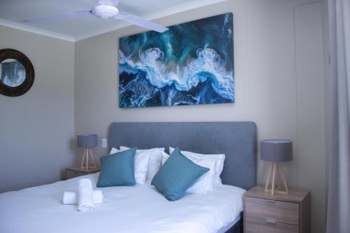 a bedroom with a bed with blue and white pillows at Ocean Breeze Hotel in Strand
