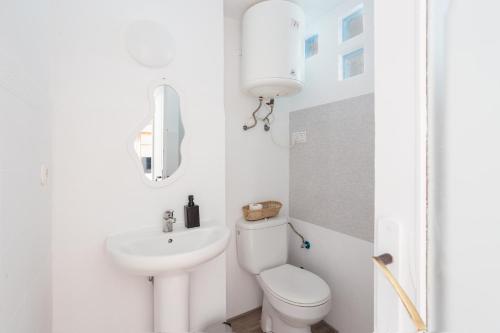 Un baño blanco con inodoro y lavabo. en Oliwood Beach - Cabaret, en Playa