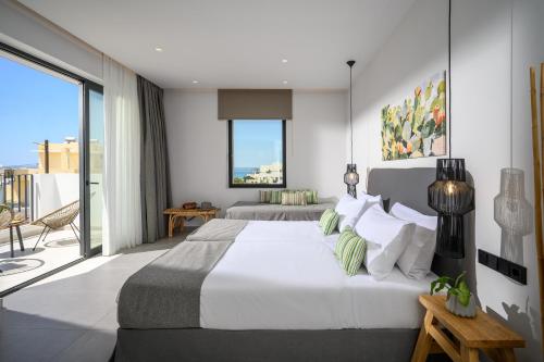 a bedroom with two beds and a balcony at Theros Hani Sea in Kokkíni Khánion