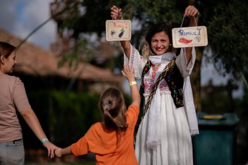 a woman and a little girl holding up signs at La Colibe, cătun arhaic ecologic in Constanţa