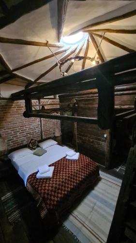 a bedroom with a bed in a room with a roof at La Colibe, cătun arhaic ecologic in Constanţa