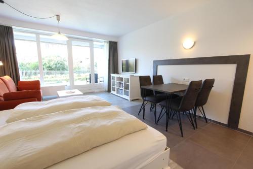 une chambre avec un lit, une table et des chaises dans l'établissement Rasmus 29, à Langeoog