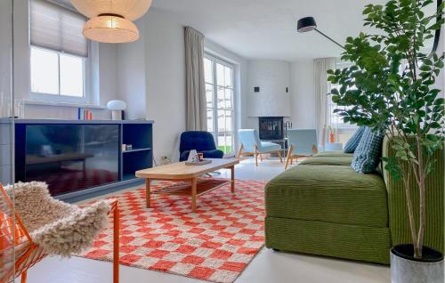 Una sala de estar con un sofá verde y una mesa. en Five Bedroom Awesome Home In Lemmer, en Lemmer