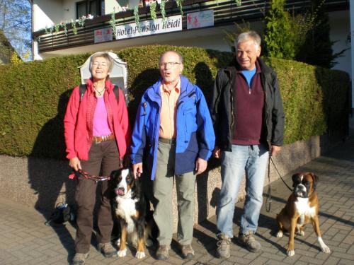 a group of three people standing with two dogs at Hotel Pension Heidi in Dobel