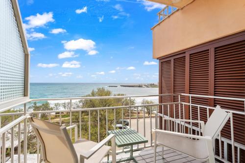 a balcony with chairs and a view of the ocean at Amena Mar Hotel in Sa Coma