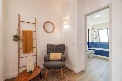 ein Wohnzimmer mit Sessel und ein Badezimmer in der Unterkunft Casa de Julho - Beach House in Livramento