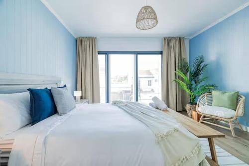 ein Schlafzimmer mit einem großen weißen Bett mit blauen Wänden in der Unterkunft Casa de Julho - Beach House in Livramento