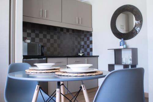 a kitchen with a table with chairs and a mirror at Ocean Breeze Hotel in Strand