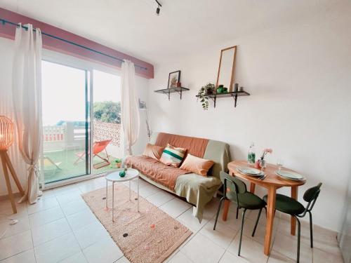 un salon avec un canapé et une table dans l'établissement T2 Unique Vue mer et accès plage - 43, à Canet