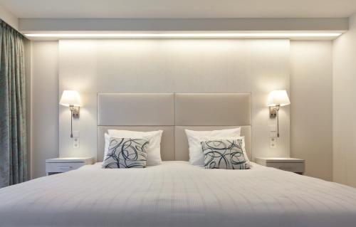 a bedroom with a large white bed with two pillows at Mondorf Parc Hotel & Spa in Mondorf-les-Bains