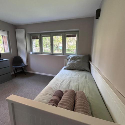 une chambre avec un lit et deux fenêtres dans l'établissement H2 Maison au pied du Château, à Fougères