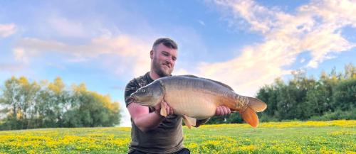 a man holding a fish in a field at Lakeview Petting Pod in Chelmsford