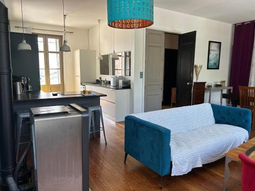 Il comprend une cuisine et un salon avec un canapé bleu. dans l'établissement La Petite Cour - Périgueux, à Périgueux