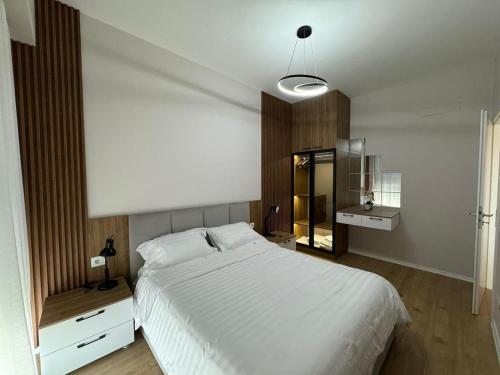 ティラナにあるTirana Center Boulevard Apartmentの大きな白いベッドと鏡のある寝室